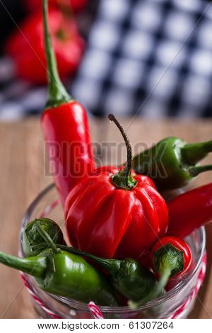 Red And Green Chili Peppers In Glass