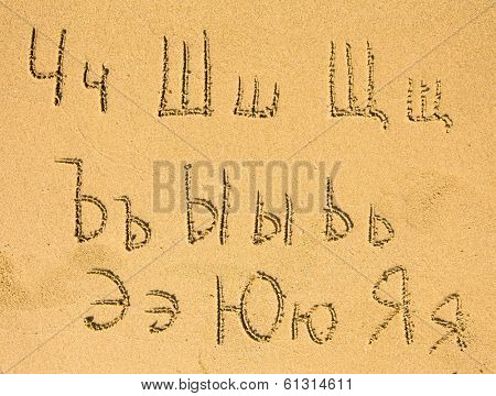 Russian alphabet (third part of three) written on a sand beach.