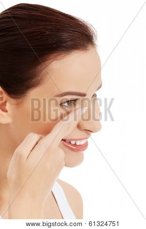 Close up of a woman putting contact lens in her eye