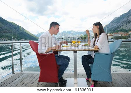happy young couple having lanch at beautiful restaurant on the beach