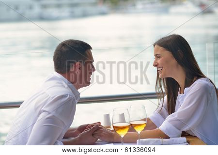 happy young couple having lanch at beautiful restaurant on the beach