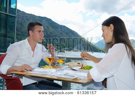 happy young couple having lanch at beautiful restaurant on the beach