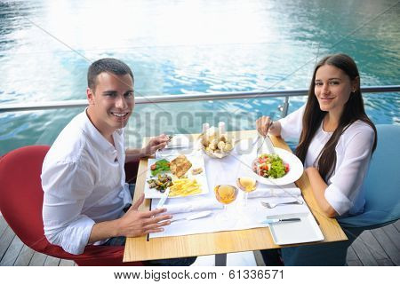 happy young couple having lanch at beautiful restaurant on the beach
