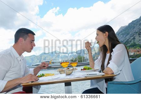 happy young couple having lanch at beautiful restaurant on the beach
