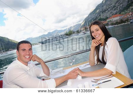 happy young couple having lanch at beautiful restaurant on the beach