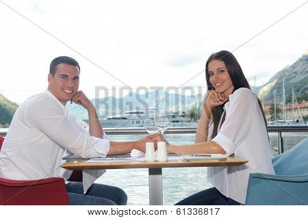 happy young couple having lanch at beautiful restaurant on the beach