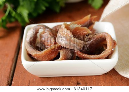 Canned marinated anchovies fillets in a white bowl
