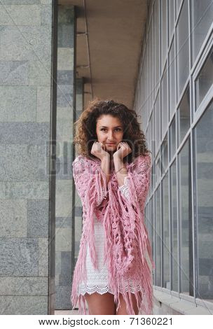 Cute curly hair girl standing near wall smiling