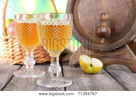 Still life with tasty apple cider and fresh apples, on nature background
