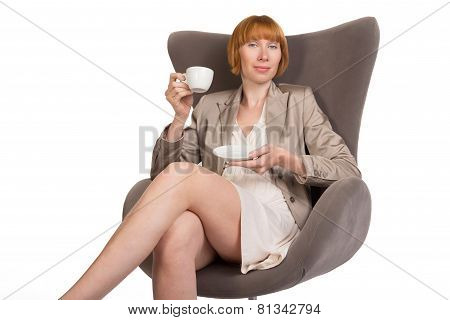 Young lady in office style sitting on modern chair with a cup of coffee