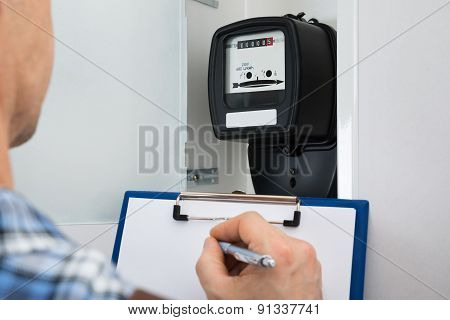 Technician Taking Reading Of Electric Meter