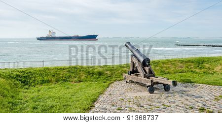 Old Cannon Focused On A Passing Freighter