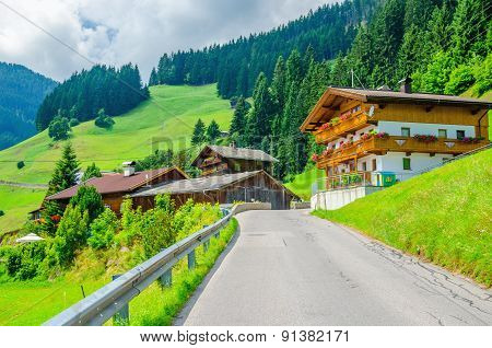 Typical alpine building oon green meadow, Austria