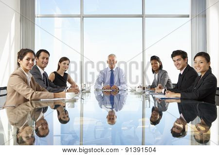 Group Of Business People Having Board Meeting Around Glass Table