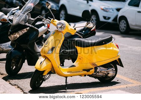 Seville, Spain - June 24, 2015: Yellow Piaggio Vespa vintage sprint motor scooter motorbike motorcycle parked in city.