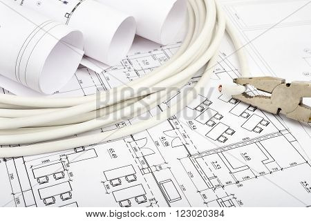 Architecture plan and rolls of blueprints with cabel and pliers. Building concept