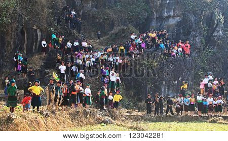 HA GIANG, VIETNAM - FEB 7, 2014: A group of unidentified Hmong women and children watching a traditional performance within a holiday called Tet under the sunlight of spring.