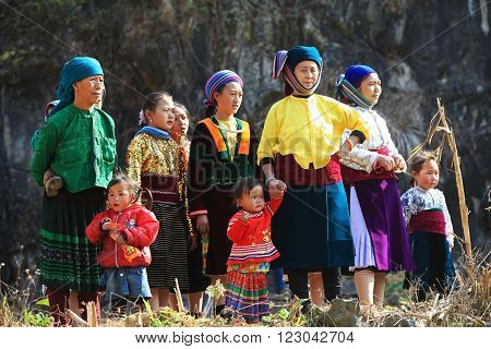 HA GIANG, VIETNAM - FEB 7, 2014: A group of unidentified Hmong women and children watching a traditional performance within a holiday called Tet under the sunlight of spring.