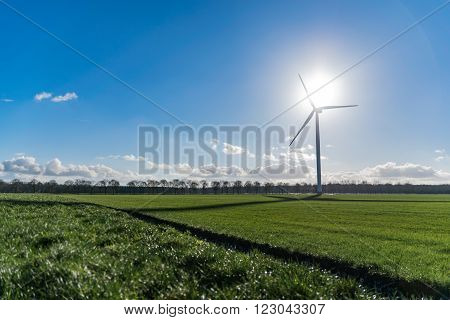 Wind turbine depicting the summit of green energy with wind and sun at highest point of the wind mill
