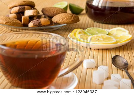 Black tea cookies sugar lemon and lime on a table