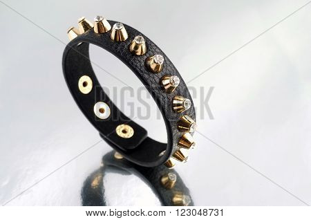 Leather bracelet with pikes on mirrorlike background