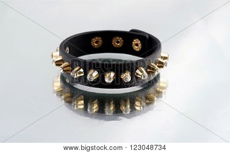 Leather bracelet with pikes on mirrorlike background