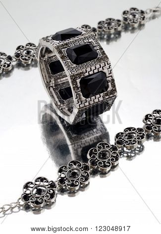 Silver bracelet with black gems on mirrorlike background