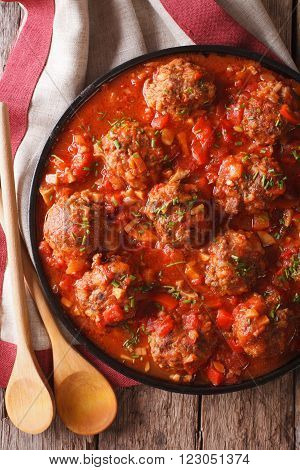 Tasty food: Meatballs albondigas with tomato sauce close-up. vertical top view
