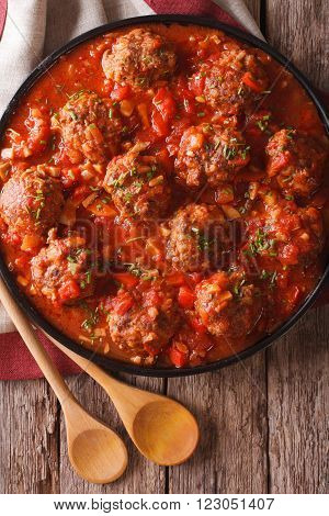 Albondigas meatballs with sauce on a plate close-up. vertical top view