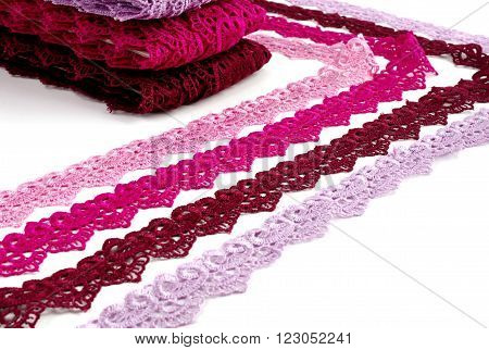 Reddish lace stretched over white background - pink, wine, raspberry-red