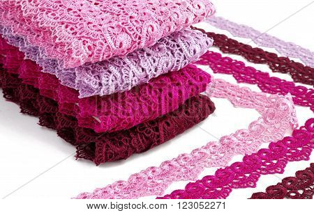 Reddish lace stretched over white background - pink, wine, raspberry-red