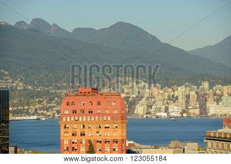 Historic Second Empire style Dominion Building and North Vancouver city skyline across Vancouver Harbour, Vancouver, British Columbia, Canada.