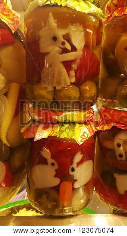 Bottled pickled vegetables in a market with funny shaped veggies inside