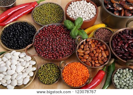 Beans peas and lentils in metal bowls.