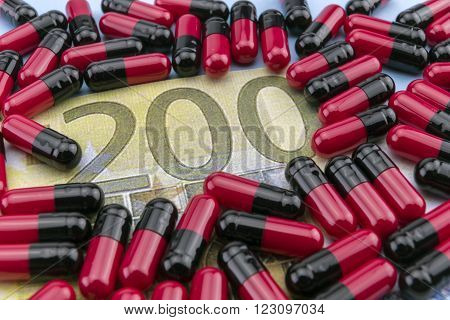 Red and black capsules up ticket of 200 euros, concept of health copay