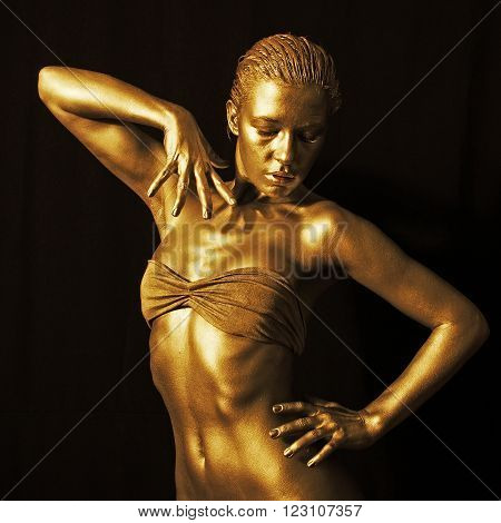 Beautiful young woman in gold posing on camera
