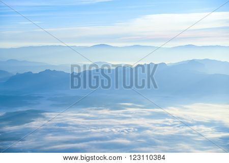Beautiful layers of mountain range landscape with winter sky from top view in majestic sunrise and fog