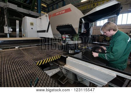 Saint-Petersburg Russia - March 23 2016: Worker young man miller is working by milling machine in working overalls shop engineering plant. The large milling machine.