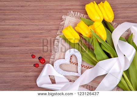 Yellow tulips and label for text on wooden background. Holiday card