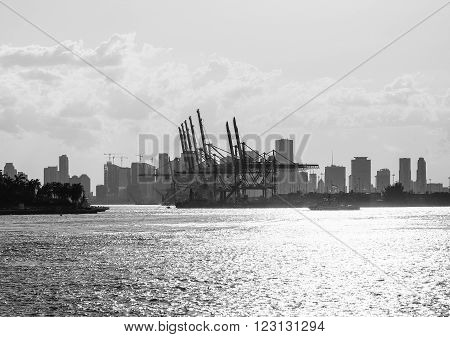 MIAMI BEACH, USA - MAY 9, 2015: The entrance to the Port of Miami with a tugboat and the skyline in the back. Captured in black and white.