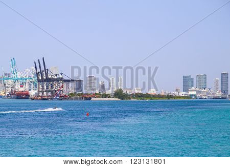 MIAMI BEACH, USA - MAY 9, 2015: The Port of Miami with big containerships cruise liners and a jet ski in front skyline in the back.