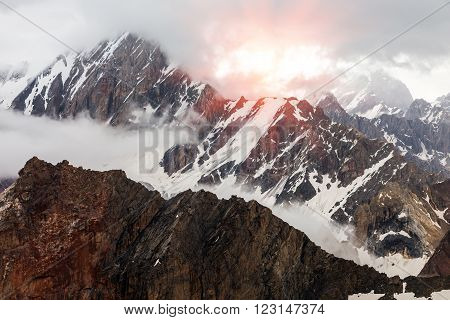 Rock Ice Snow Cliff Ridge Overcast Cloudscape Sky and Sun Shining