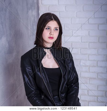 Teen Girl Posing In A Studio On A Dark Background In Leather Jacket
