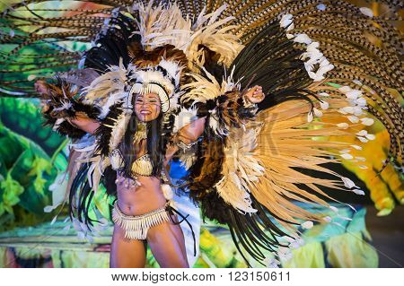 Parintis Brazil December 06 2015: One attractive smiling  tallanted dancer woman in bikini and carnival feather costume bright colors and painted face in mask horizontal photo