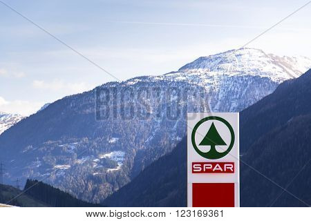 MATREI IN OSTTIROL, AUSTRIA - MARCH 28: Dutch multinational retail chain and franchise Spar logo with moutains in background on March 28, 2012 in Matrei in Osttirol, Austria.