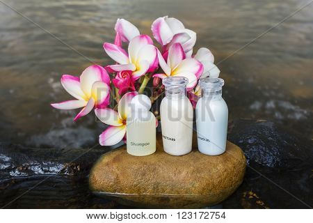 Mini Set Of Bubble Bath Shower Gel Liquid With Flowers And Pebble On Waterfall Rock