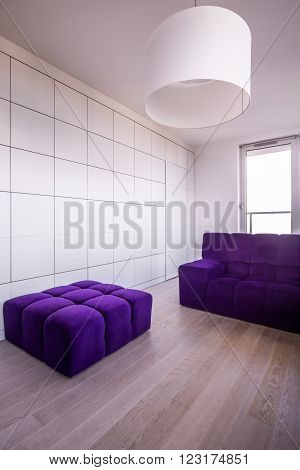 Violet hassock and couch in minimalist modern flat