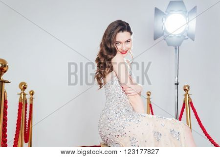Smiling pretty woman in fashion dress looking at amera