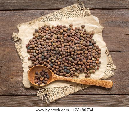 Raw organic roveja beans with a spoon on a wooden table