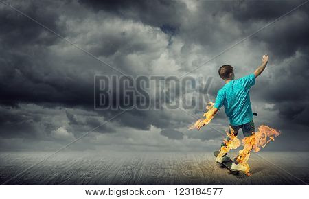 Skater boy riding on his skateboard burning in fire